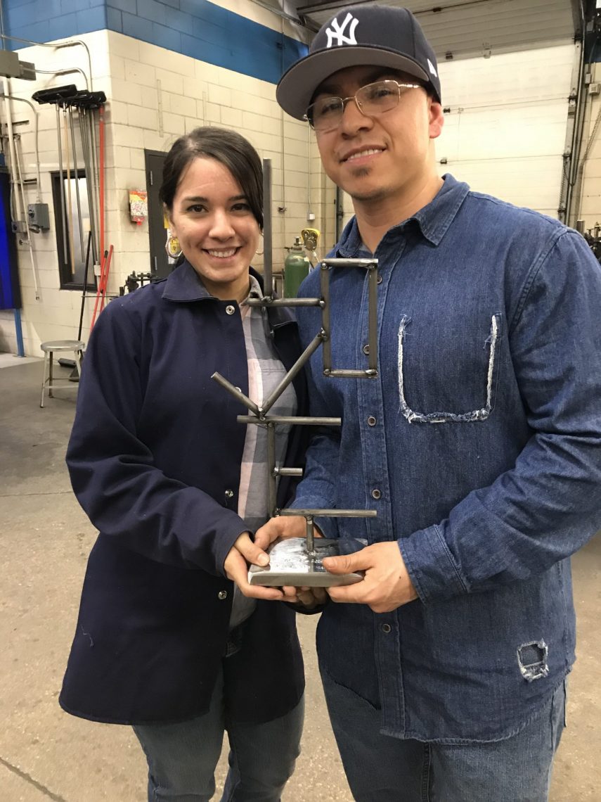 Male and female IET welding students holding a welding project