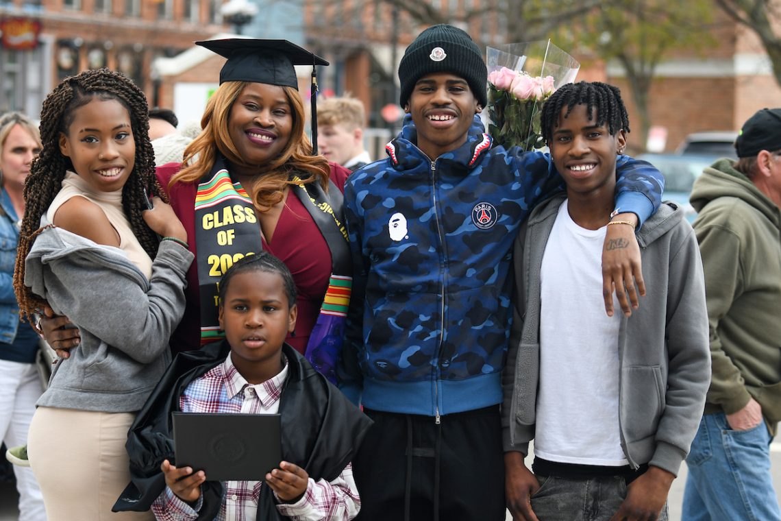 MPTC graduate and mother of four standing outside with cap and sash on, following commencement